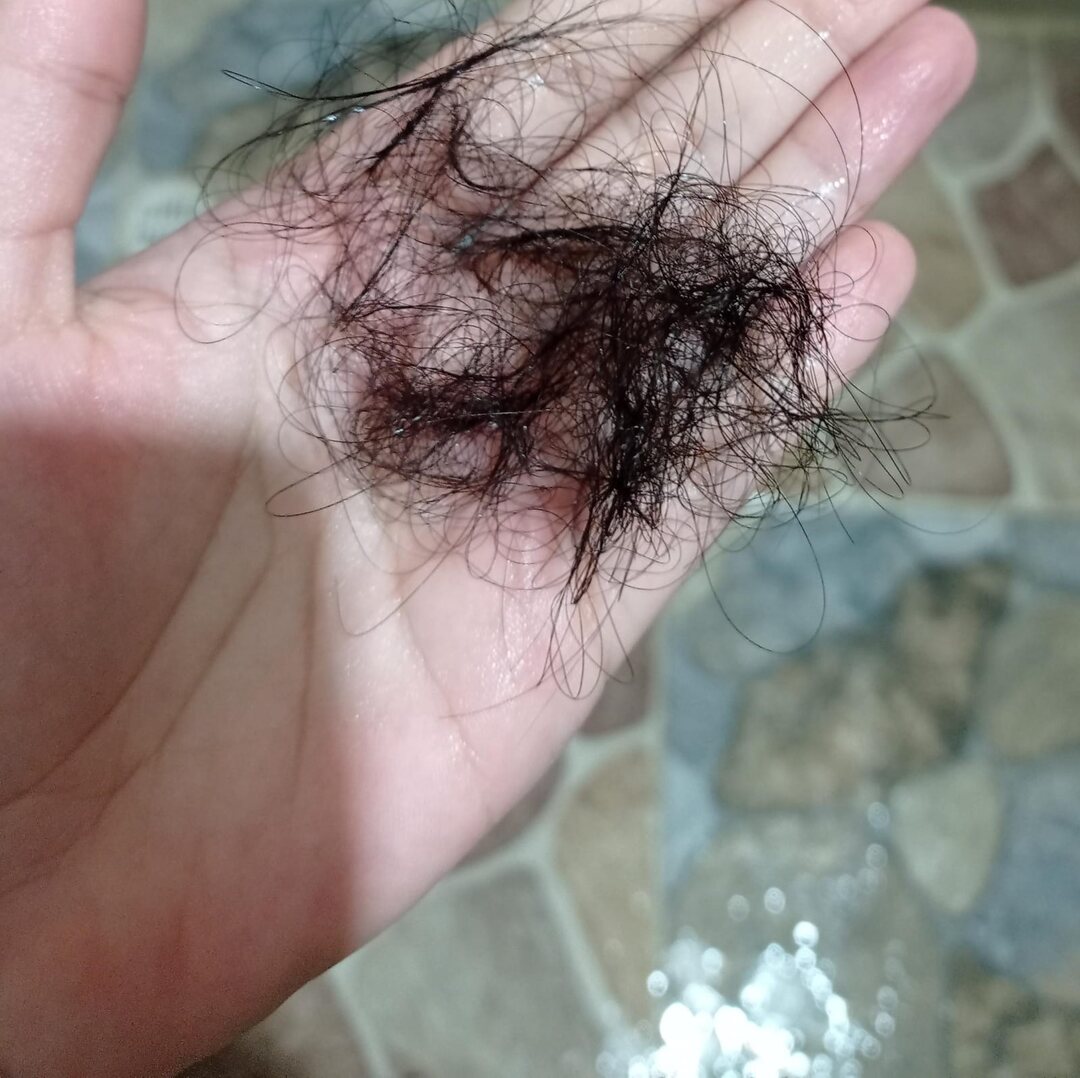 Cabello caido en la mano durante el lavado